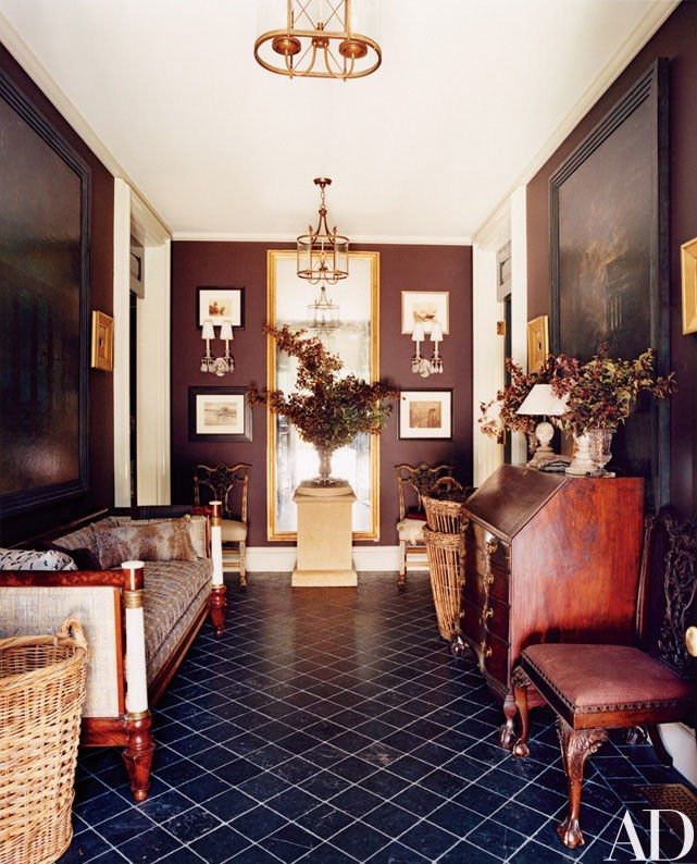 a living room filled with furniture and pictures on the wall next to a doorway that leads to another room