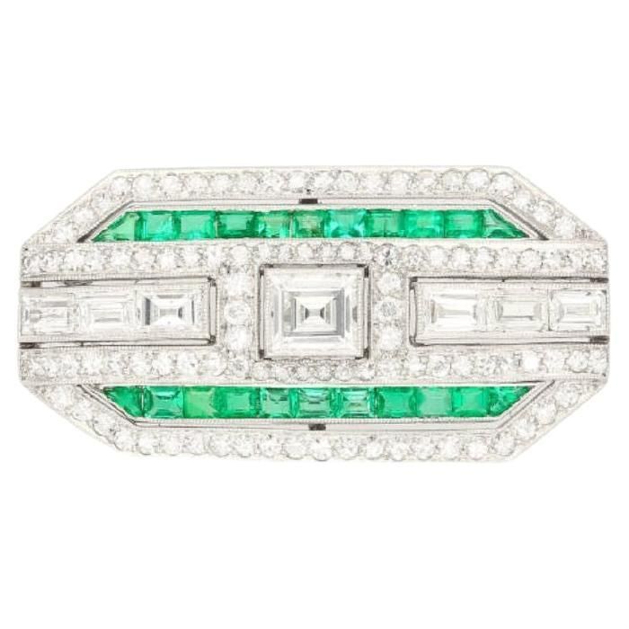 Art Deco pendant/brooch featuring a rectangular step-cut diamond of approx. 1.65 carats, accented by full and single-cut diamonds weighing a total of approximately 2.00 carats. Flanked by calibré-cut synthetic emeralds, set in platinum, signed Bert H. Satz. Item Details: - Type: Pin - Metal: Platinum / 18K White Gold - Weight: 10.56 grams - Style: Minimalist - Era: 21st Century - Setting: Bezel - Dimensions: 1-7/16 inches x 11/16 inch Center Stone Details: - Type: Diamond - Cut: Baguette - Measurements: 6.6 x 5.55 MM - Quantity: 1 Side Stone Details(1): - Type: Diamond - Cut: Baguette - Quantity: 6 Side Stone Details(2): - Type: Diamond - Cut: Round - Quantity: 102 Side Stone Details(3): - Type: Emerald - Carat: 5 (approx.) - Cut: Trillion - Color: Green - Quantity: 22 ____________________ David Webb, Art Deco Pendant, Gold Brooch, Gold Brooches, Art Deco Diamond, Italian Charm Bracelet, Diamond Cut, Estate Jewelry, 21st Century