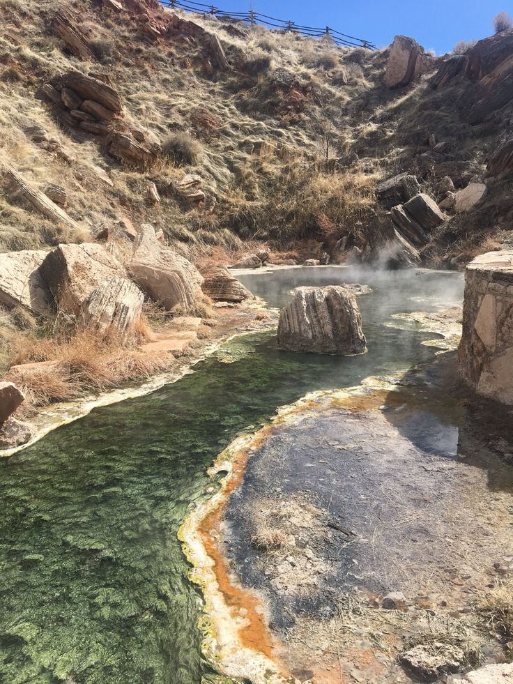 hot springs in the mountains with steam coming from them