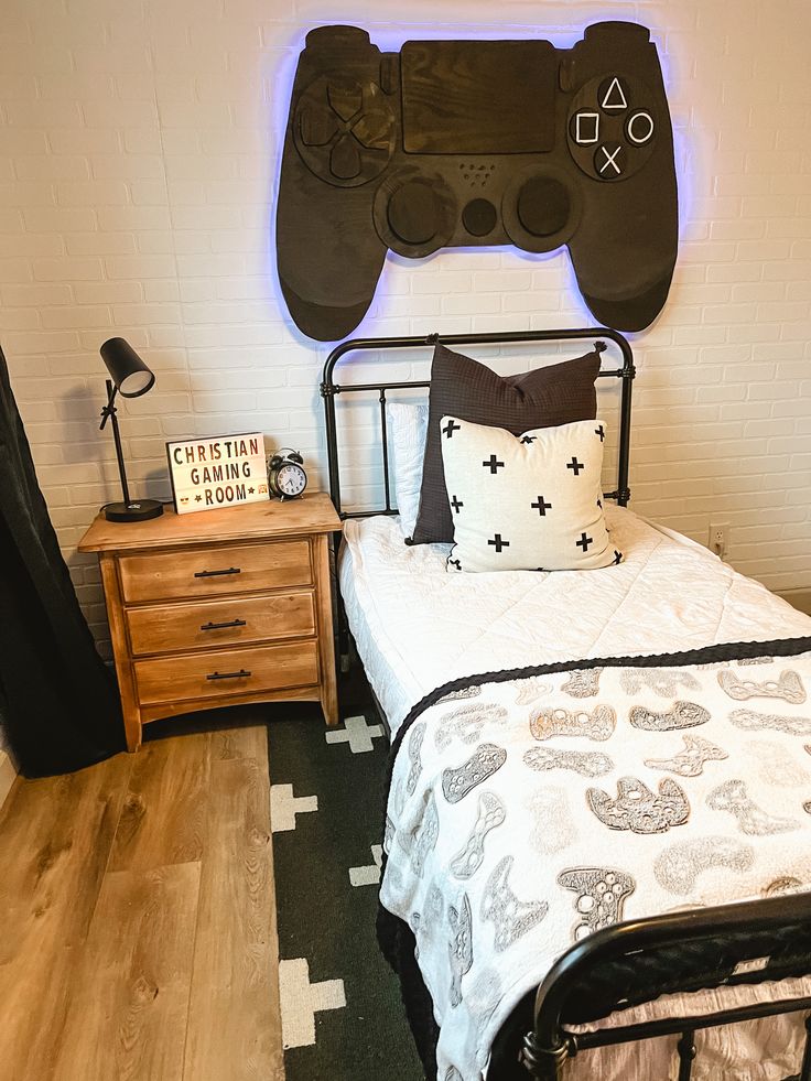 a bed room with a neatly made bed and a video game controller on the wall