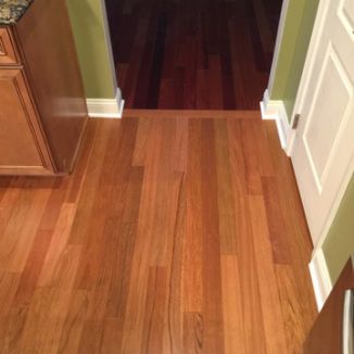 an open door leading into a kitchen with wood floors