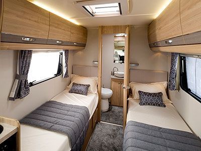 the inside of a camper with two beds and a toilet