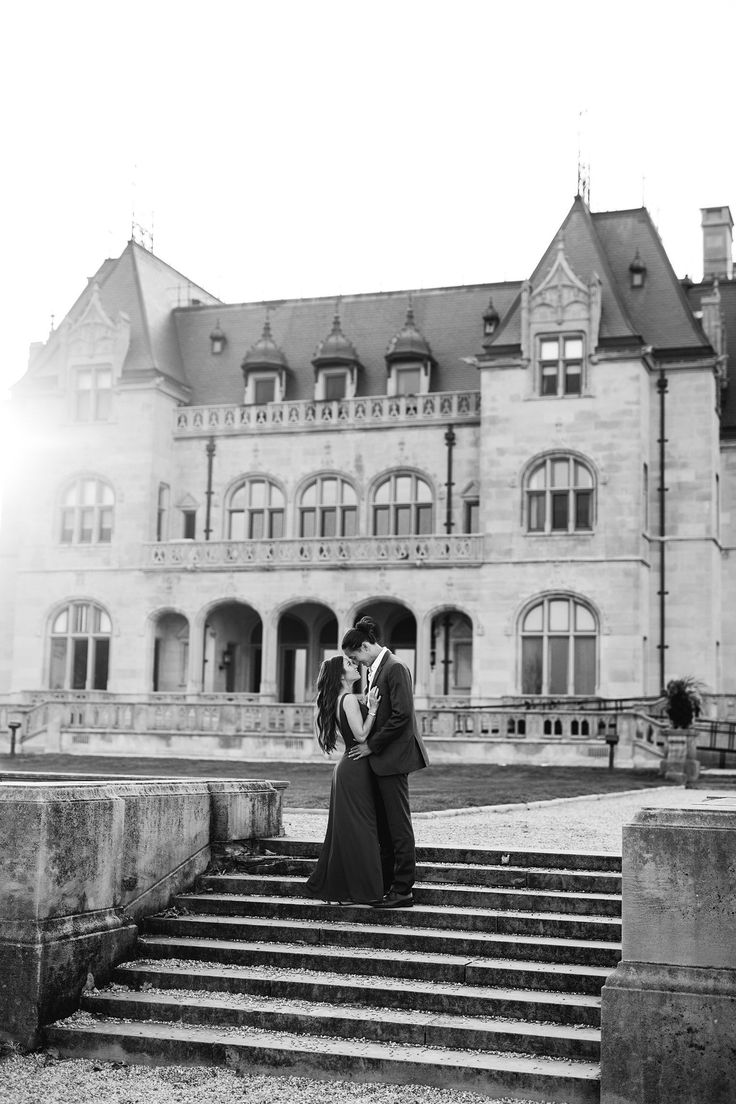 a man and woman standing on steps in front of a large building