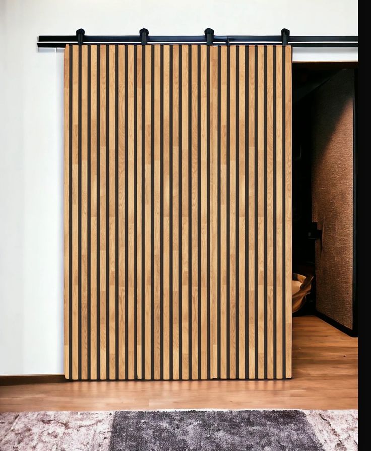 a wooden sliding door with vertical slats on the top and bottom bars, in front of a white wall