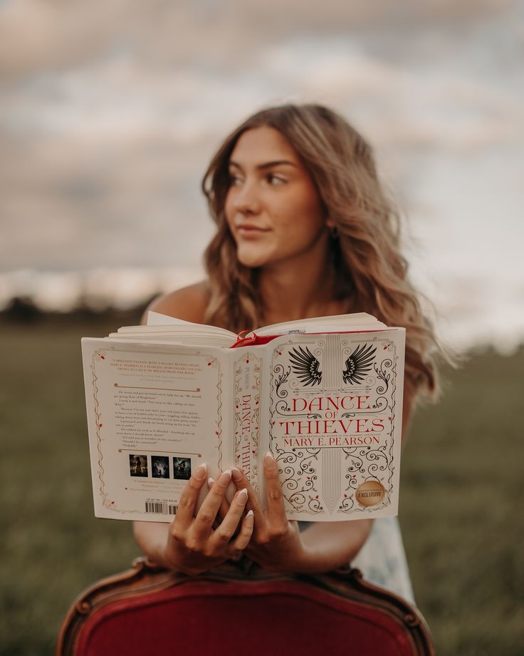 a woman sitting in a chair reading a book