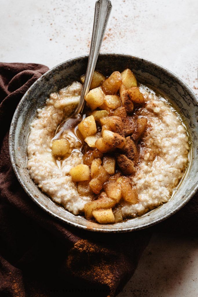 a bowl of oatmeal topped with apples and cinnamon