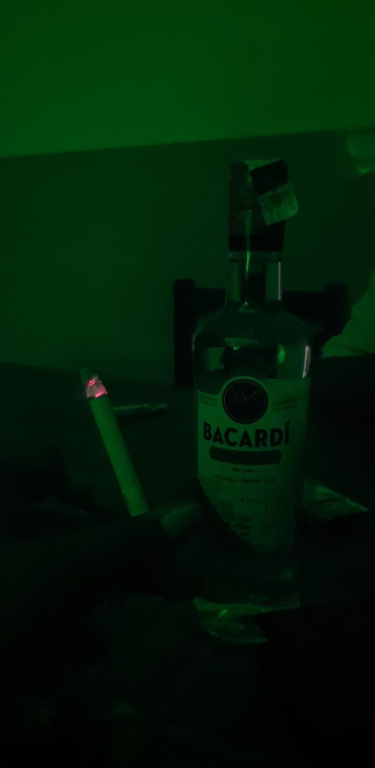 a bottle of bacardi sitting on top of a table next to a lighter