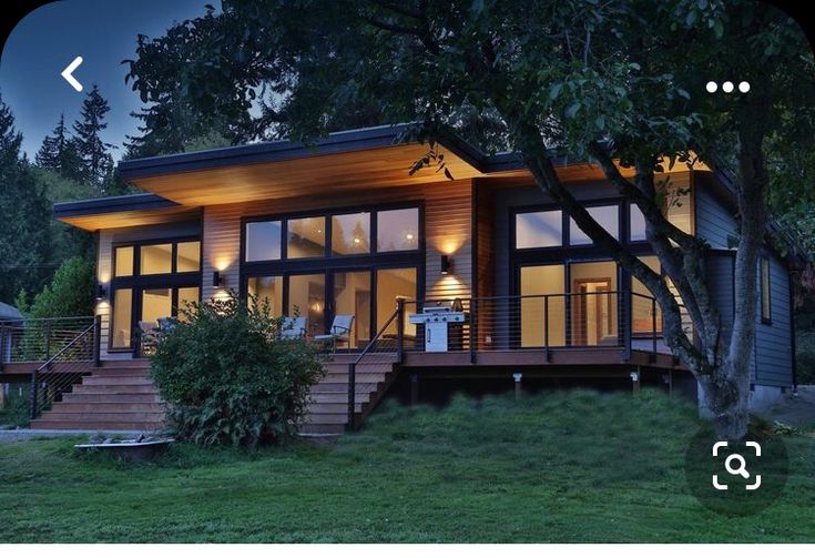 a house that is lit up in the evening with lights on it's windows