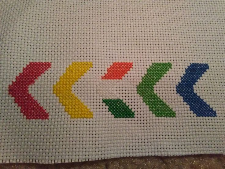 a cross stitch pattern with an arrow on the bottom and four colors in the middle