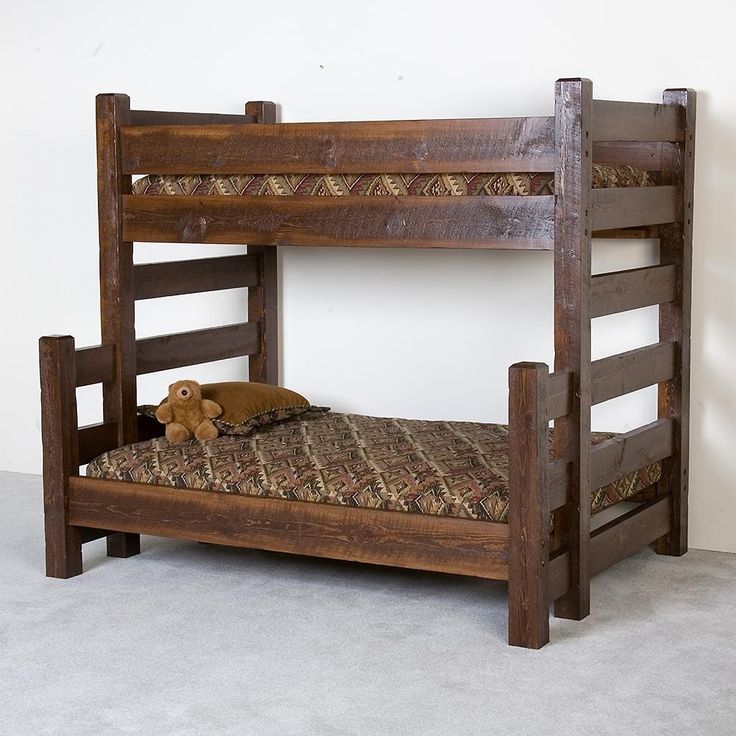 a wooden bunk bed sitting next to a wall with two teddy bears on top of it