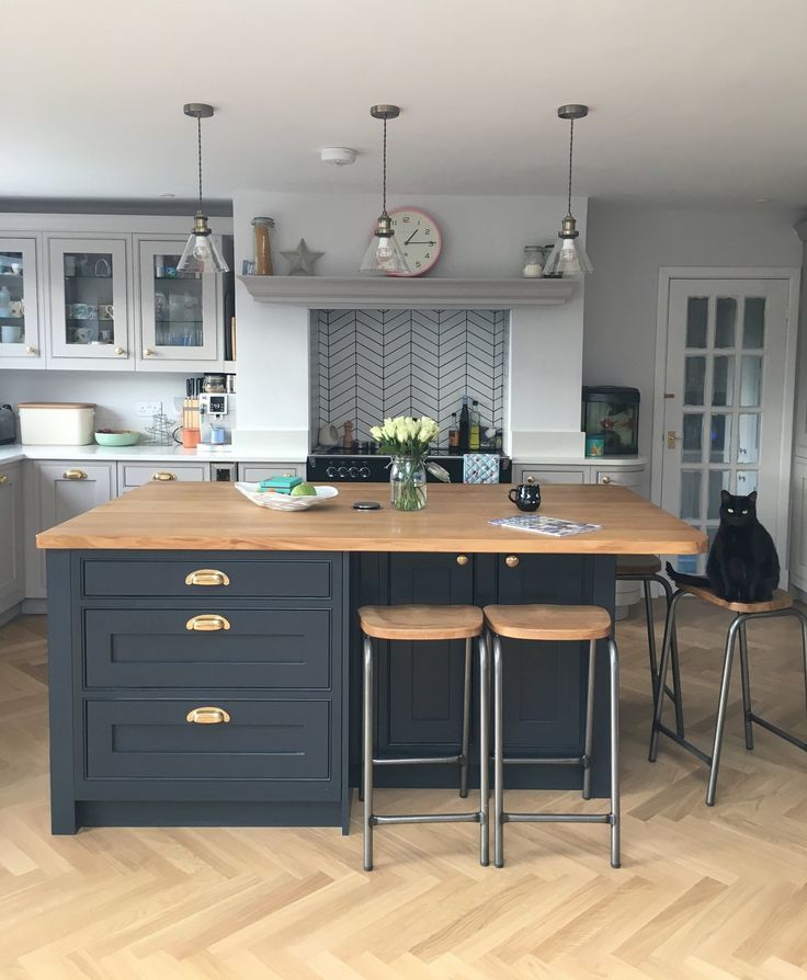 a kitchen island with two stools in front of it and a clock on the wall