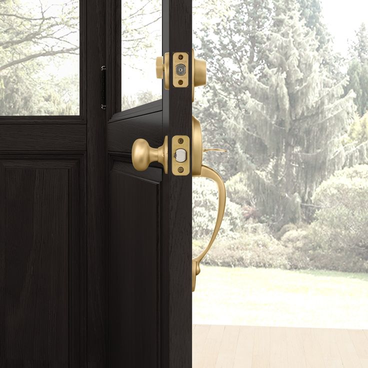 an open door with the handle on it in front of a wooden floor and trees