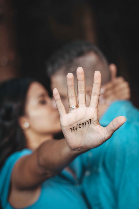 a man and woman holding up their hands with the word love written on it in front of them