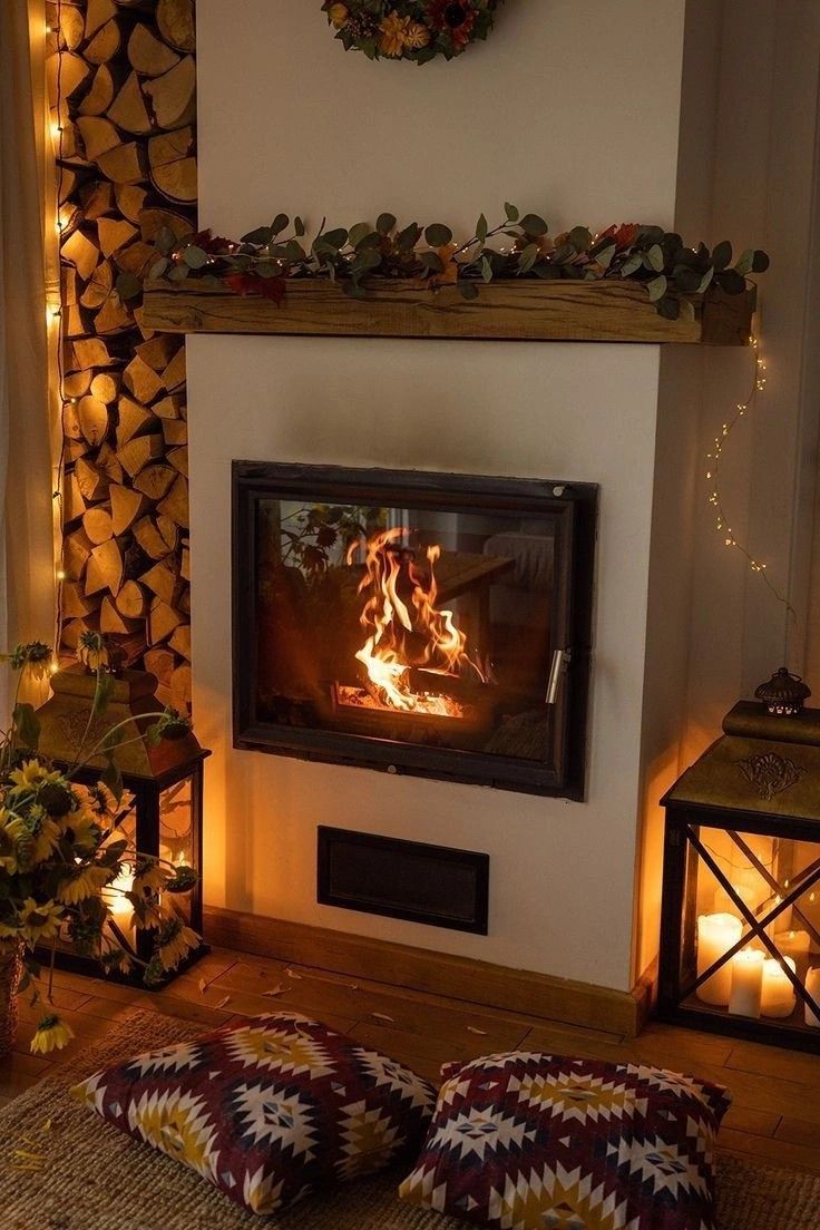 a living room with a fire place in the center and two pillows on the floor