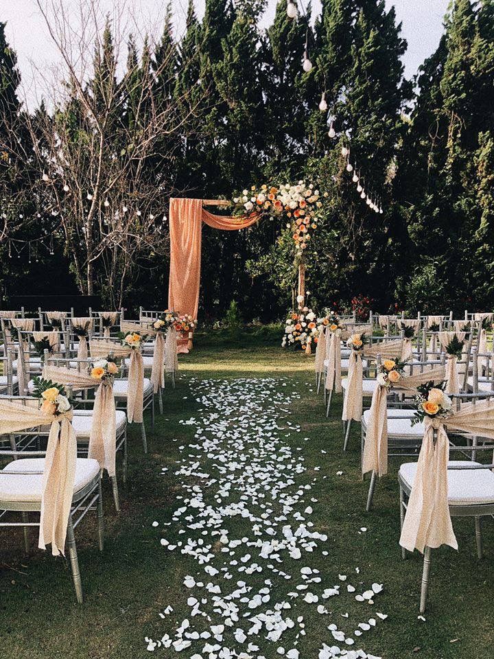 an outdoor wedding setup with white chairs and flowers on the aisle leading up to the ceremony