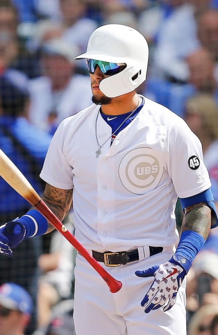 a baseball player holding a bat in his hand and wearing sunglasses on top of his head