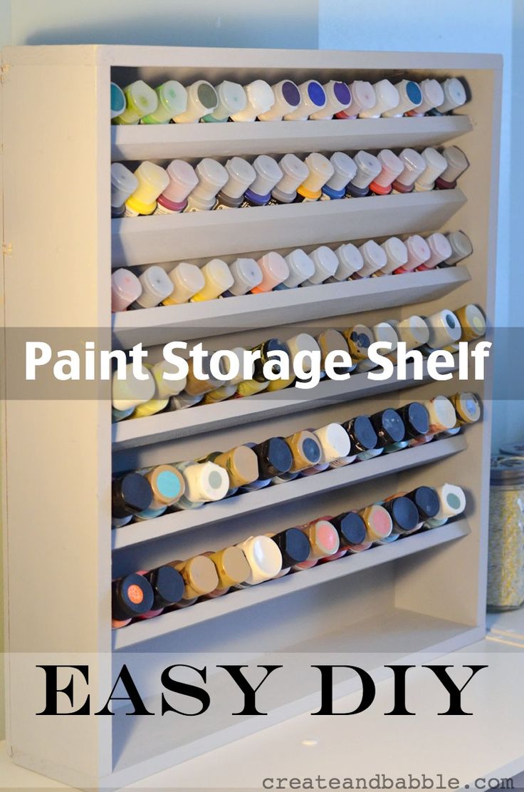 a white shelf filled with lots of different colored items next to a wall mounted mirror