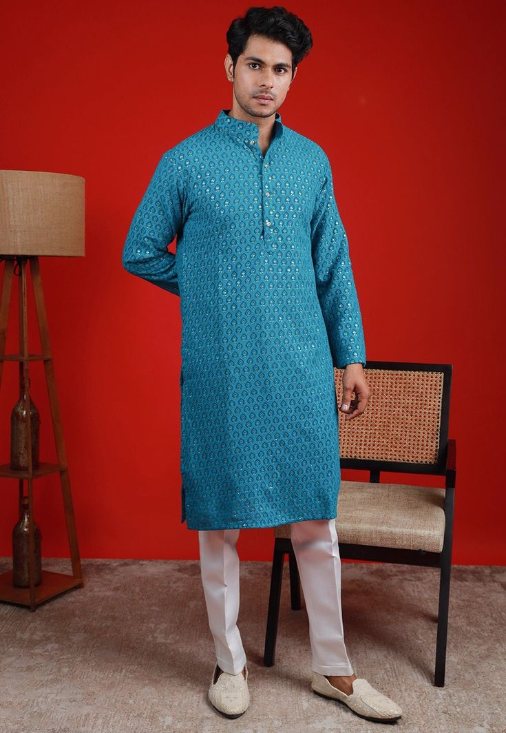 Faux Georgette Kurta in Teal Blue. This Readymade Chinese Collar Neck and Full Sleeve attire is Enhanced with Fancy Buttons, Resham and Sequins Work Available with a Cotton Silk Aligarhi Pant in White Do note: Footwear shown in the image is for presentation purposes only. Half to one inch may vary in measurement. (Slight variation in actual color vs. image is possible) We sell all kinds of menswear. Mens Kurta | Mens Kurta Pajama | Mens Sherwani | Mens Sherwani Sets | Traditional Menswear | Part Blue Festive Traditional Wear With Long Sleeves, Fitted Light Blue Traditional Wear With Long Sleeves, Blue Long Sleeve Festive Traditional Wear, Blue Long Sleeve Kurta With Zari Work, Blue Long Sleeve Kurta For Diwali, Blue Sets With Chikankari Embroidery For Transitional Season, Blue Sets With Dabka Work For Spring, Embroidered Blue Traditional Long Sleeve Wear, Traditional Blue Kurta For Spring