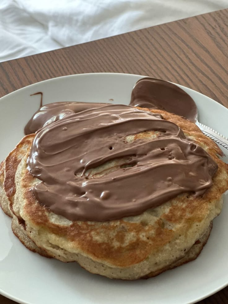 a chocolate frosted pastry on a white plate