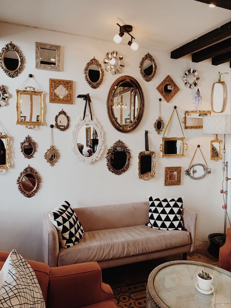 a living room filled with furniture and lots of mirrors on the wall above it's couch