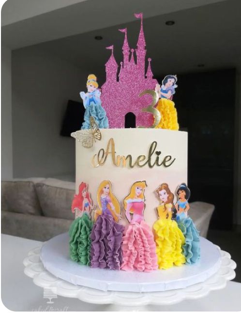 a birthday cake decorated with princesses and the word anette on it's side