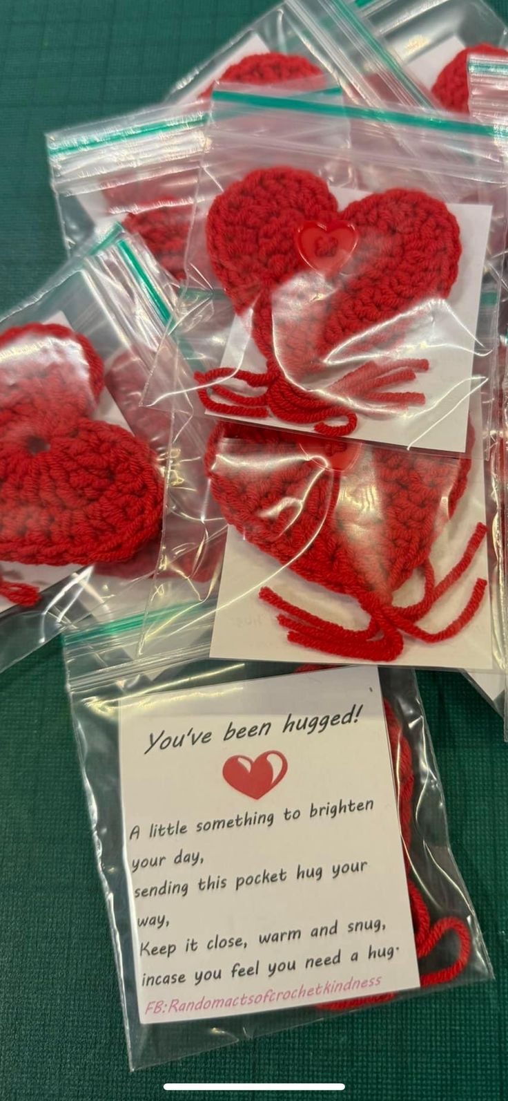 red crocheted hearts in cellophane wrapped in clear plastic with card saying you've been hugged