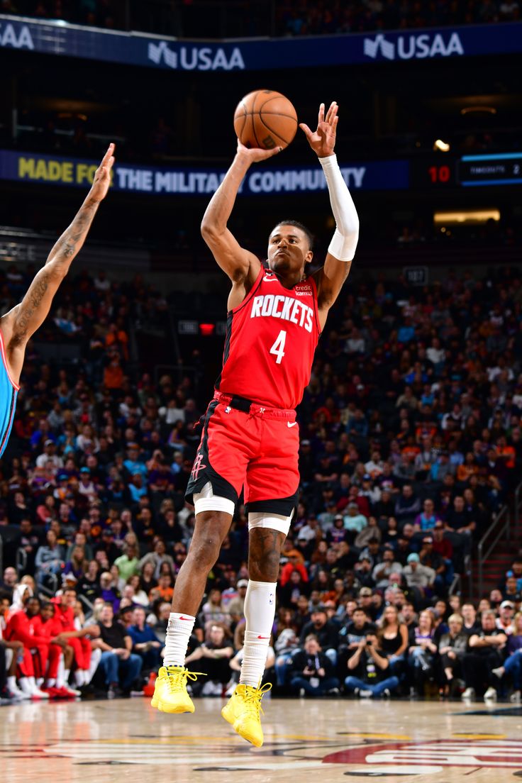 the basketball player is trying to block the ball from going up for it's basket