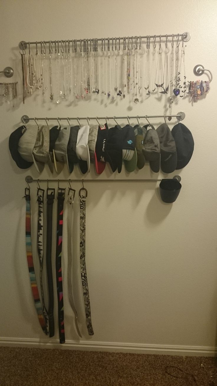 a rack with hats and ties hanging from it's sides next to a wall