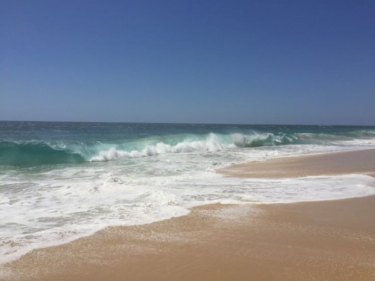 the ocean waves are crashing on the beach