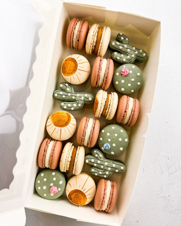 a box filled with macaroons covered in frosting