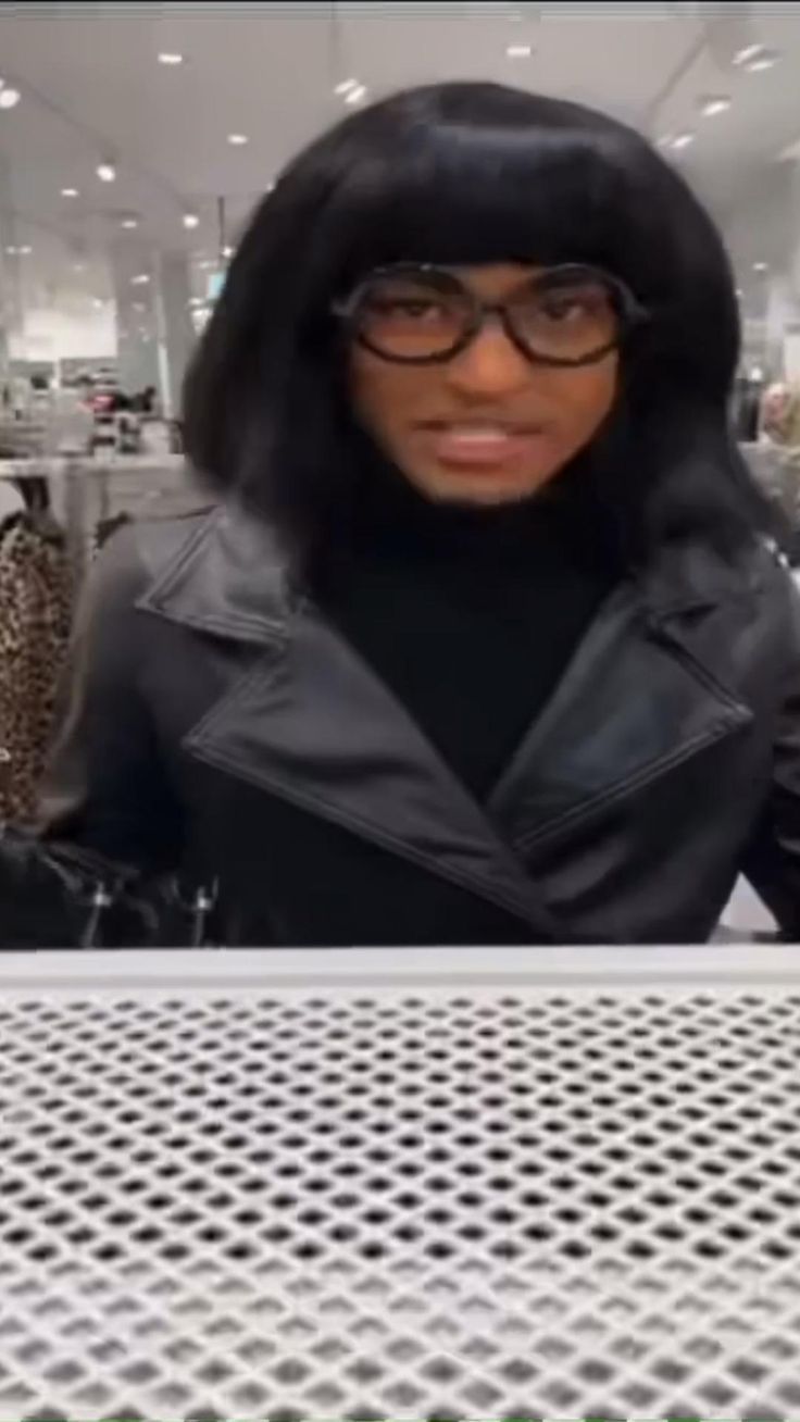 a woman wearing glasses standing in front of a table