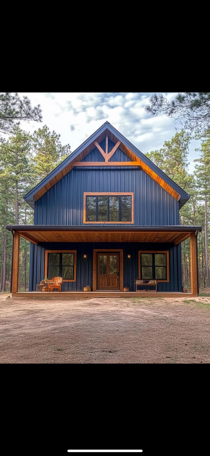 a large blue house sitting in the middle of a forest