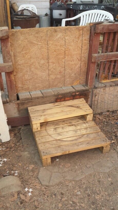 two wooden steps sitting next to each other in front of a fence and building materials