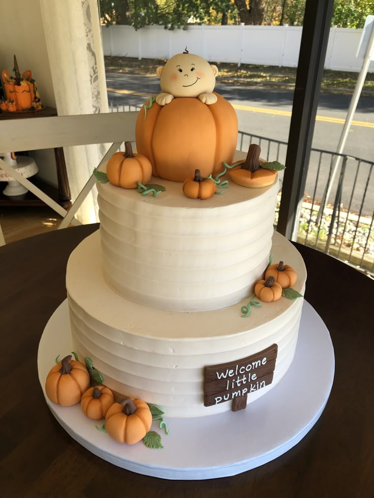 a three tiered cake decorated with pumpkins and a monkey sitting on top of it