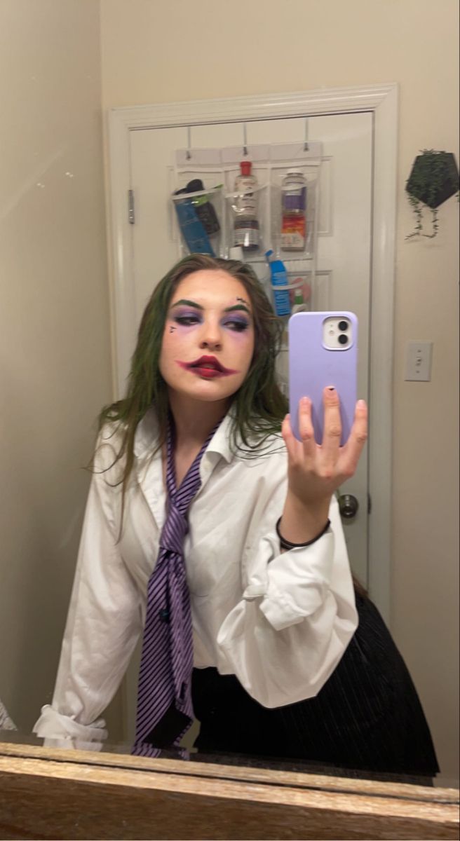 a woman taking a selfie in front of a mirror with makeup on her face