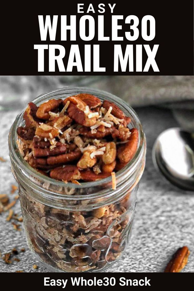 an easy recipe for whole 30 snack trail mix in a glass jar with spoons on the side