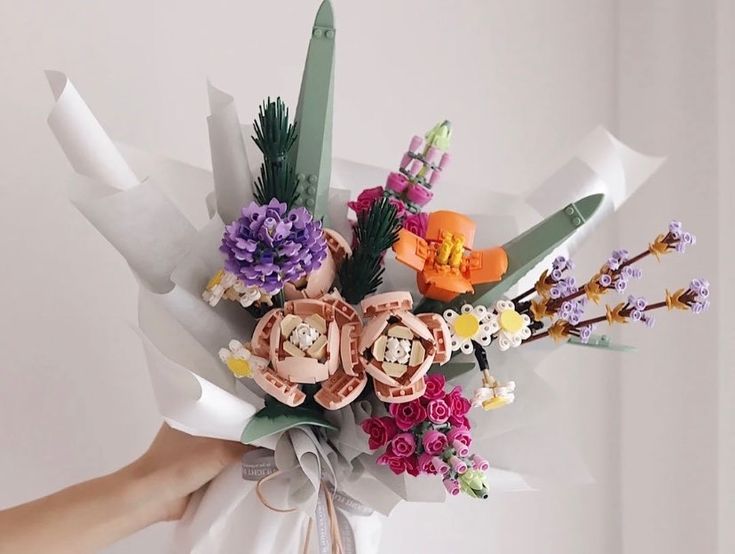 a person holding a bouquet of flowers in their left hand and wearing a white shirt