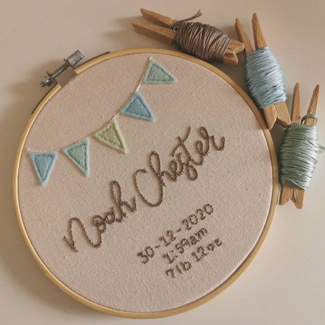 a close up of a embroidery on a hoop with yarn and needles next to it