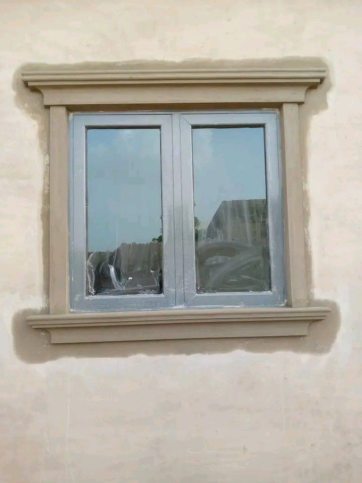 a cat sitting on the ledge of a window