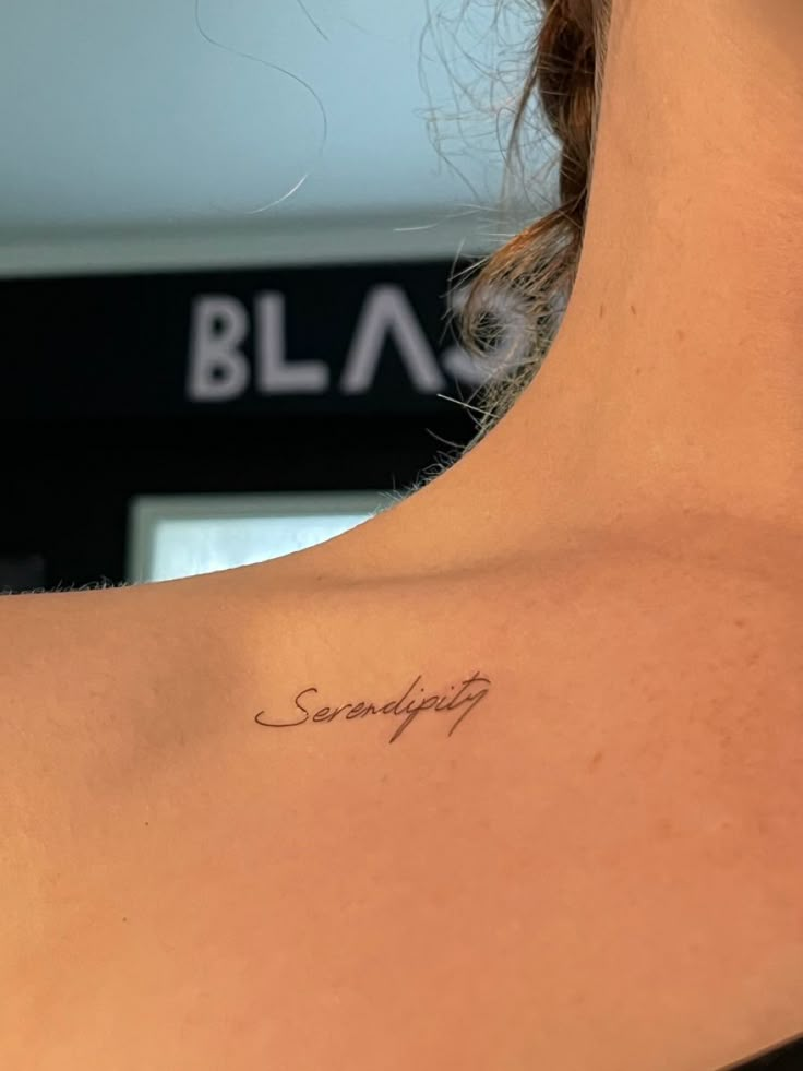 the back of a woman's shoulder with writing on it that says, something