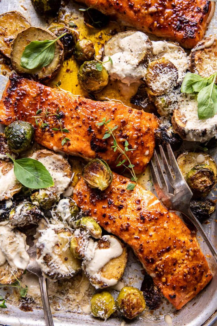 a plate with salmon, potatoes and brussels sprouts topped with parmesan cheese