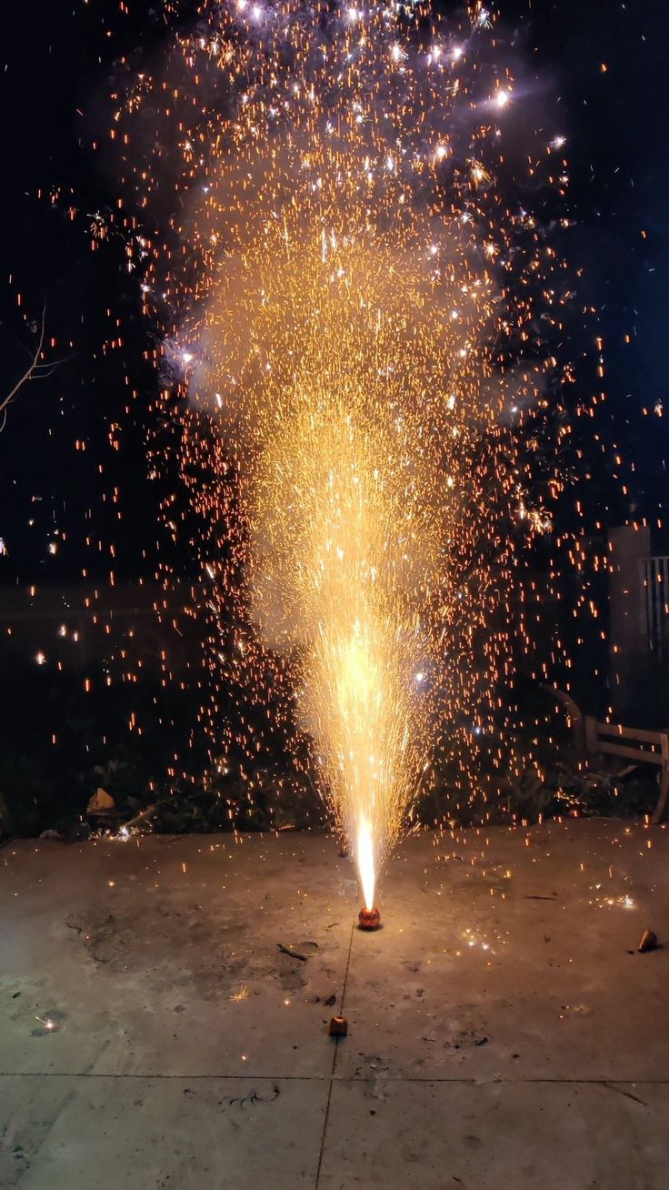 a firework is lit up in the night sky with lots of sparks coming from it