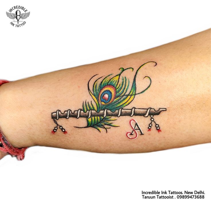 a peacock tattoo on the arm with letters and numbers written in cursive writing