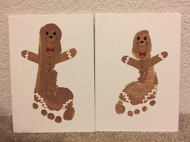 two handprinted gingerbreads sitting on top of each other in front of a wall