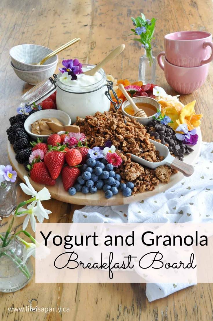 yogurt and granola breakfast board on a wooden table with flowers in the background