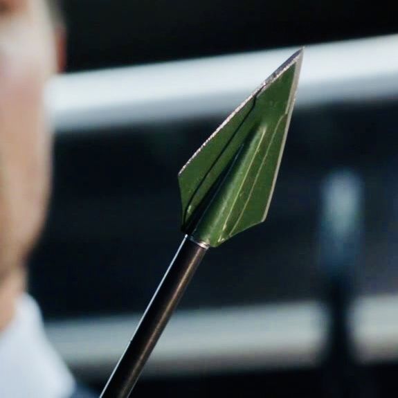 a close up of a person holding a green arrow