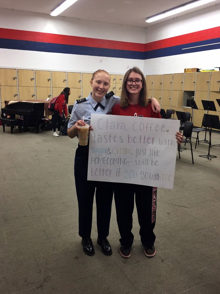 two people standing next to each other holding a sign