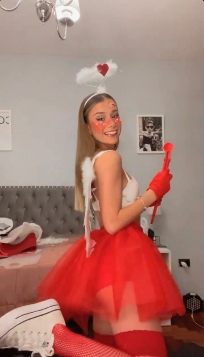 a woman in a red tutu skirt and white top is posing for the camera