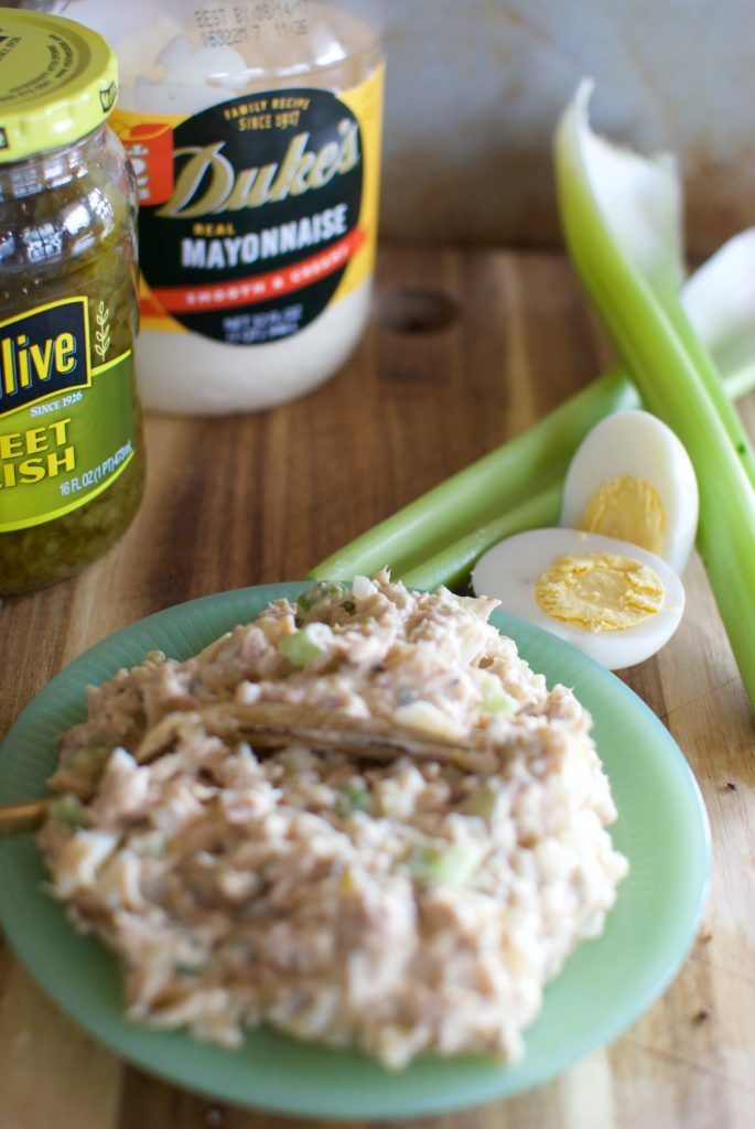 a green plate topped with rice and celery next to some mayonnaise