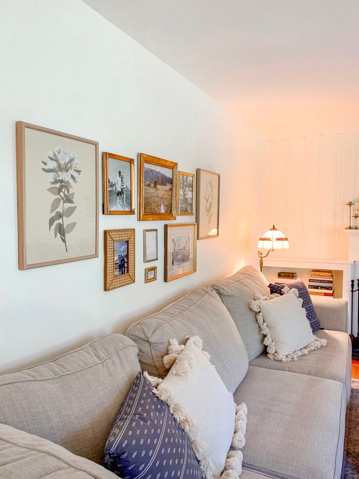 a living room filled with lots of furniture and pictures on the wall above it's couch